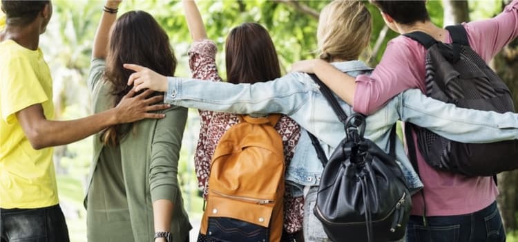 A group of young people embracing each other.